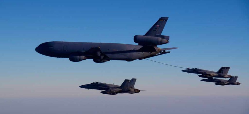 A KC-10A tanker refuels one of the Navy's F/A 18 fighter jets