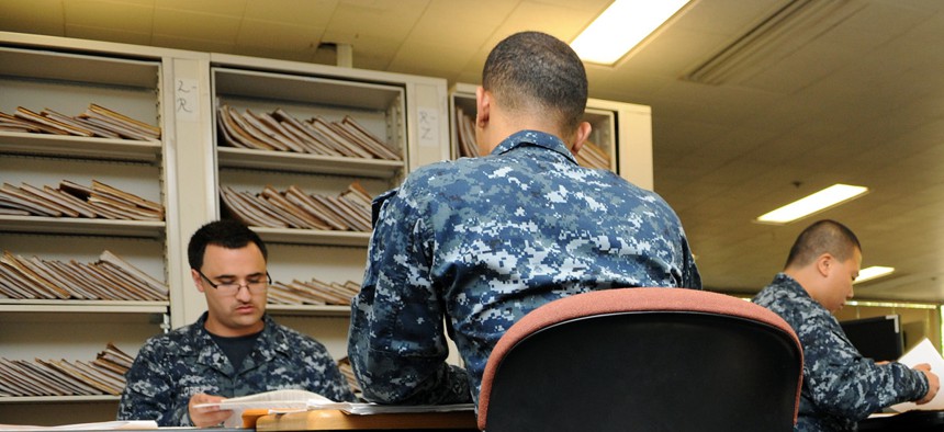Navy personnel specialists convert Enlisted Field Service Records to electronic files at the Naval Medical Center San Diego, July 28, 2010. 