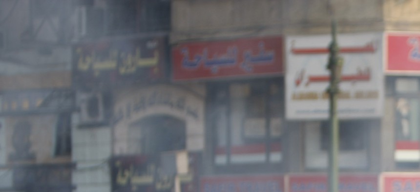 A protestor throws a canister of tear gas during a demonstration in Cairo, Egypt on January 25, 2011