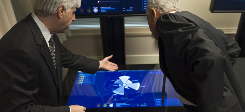 Secretary of Defense Chuck Hagel listens to a brief during a Defense Advanced Research Projects Agency demonstration at the Pentagon April 22, 2014. 