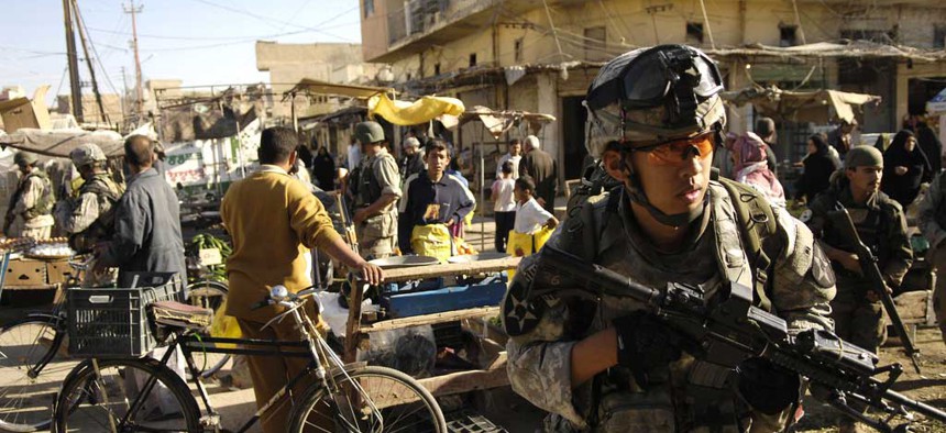 An Army specialist move through an open air market during a foot patrol in Baqubah, Iraq, on April 5, 2007.