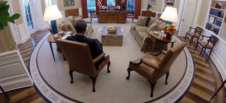 President Obama reads briefing material in the Oval Office, on August 29, 2014.