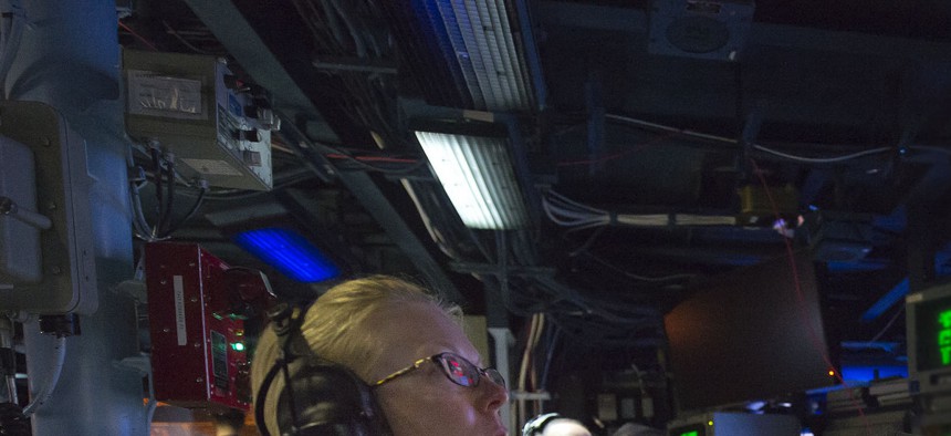 The commanding officer of the USS Arleigh Burke observes operations in the combat information center. 