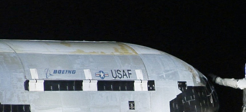 Air Force personnel conduct checks on the X-37B vehicle after a landing at Vandenberg Air Force Base, on December 3, 2010. 