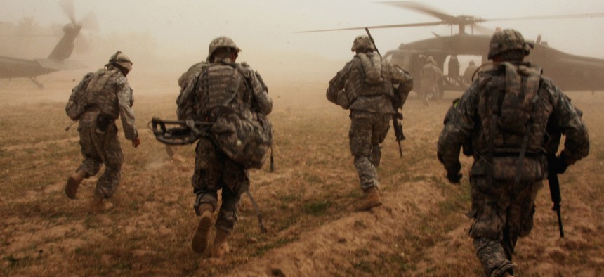 Soldiers with the 101st Airborne Division run to UH-60 Blackhawk helicopters after conducting a search for weapons caches in Albu Issa, Iraq. 