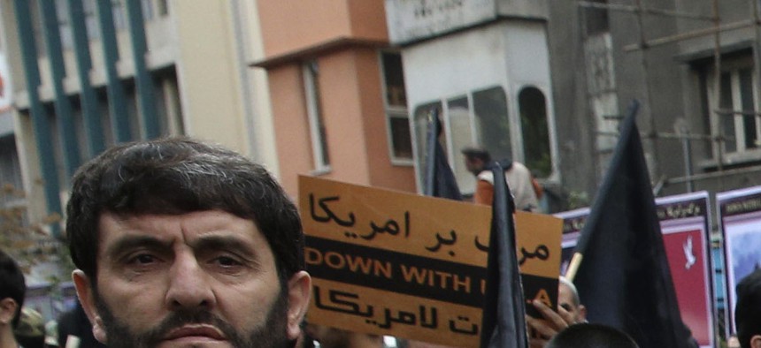 Iranians stand in an anti-U.S. demonstration in front of the former U.S. Embassy, during the holy day of Ashoura, in Tehran, Iran, Tuesday, Nov. 4, 2014. 