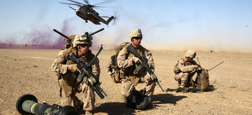 A group of Marines provide security as a CH-53 Super Sea Stallion helicopter lands during a mission in the Helmand Province, on April 28, 2014.