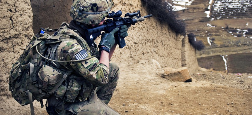 An Army sergeant scans a nearby mountain range during a search of Qual-e Jala village in Afghanistan.