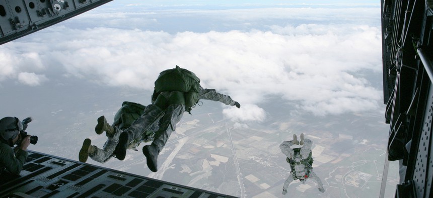 Members of the U.S. Army Special Forces soar out of the back of a C-17 during a HALO training exercise.