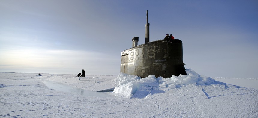 Sailors and members of the Applied Physics Laboratory Ice Station clear ice from the hatch of the USS Conecticutt, on March 19, 2011.