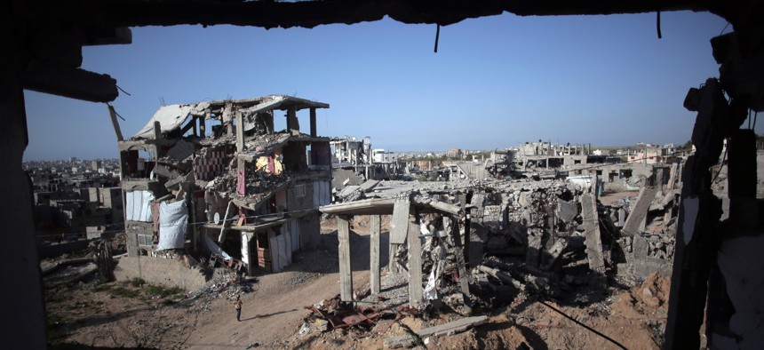 A Palestinian girl walks next to destroyed houses, in the Shijaiyah neighborhood of Gaza City, Monday, March 30, 2015. 