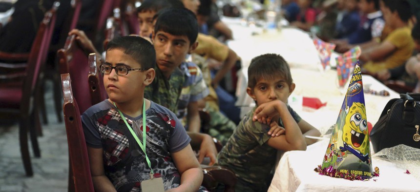Iraqi orphans watch a skit by members of the Iraqi Artists Association during an event organized by the association in Baghdad, Iraq, Saturday, April 4, 2015.