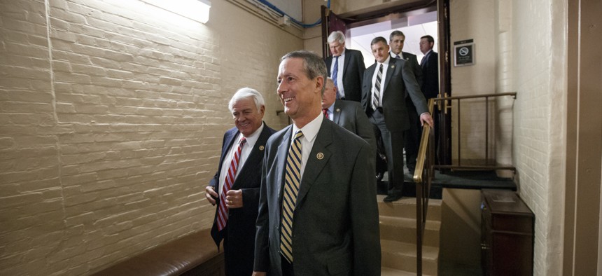 Rep. Mac Thornberry, R-Texas, center, and other House Republicans emerge from a closed-door meeting in the basement of the Capitol on how to deal with the impasse over the Homeland Security budget, in Washington, Thursday night, Feb. 26, 2015. 