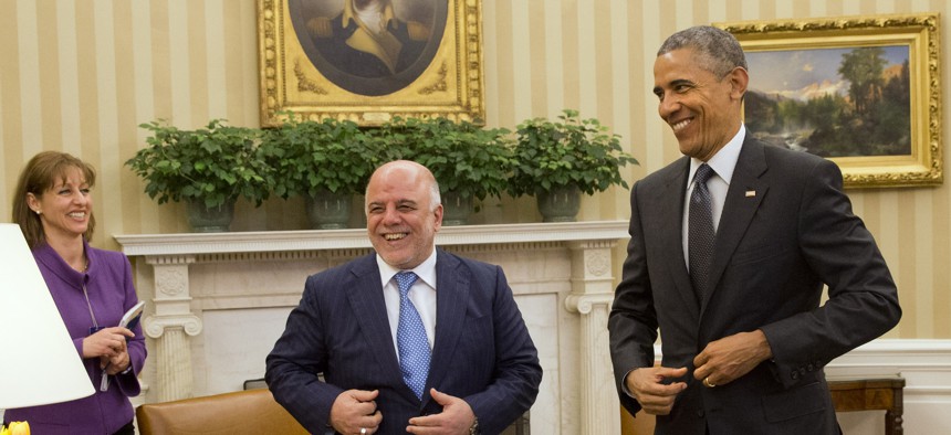 Iraqi Prime Minister Haider Al-Abadi and President Barack Obama fix their suit jackets as they finish their meeting in the Oval Office of the White House in Washington, Tuesday, April 14, 2015. 
