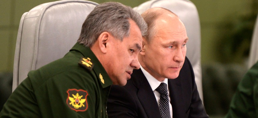 Russian President Vladimir Putin, right, speaks with Defense Minister Sergei Shoigu as he visits the National Defense Control Center in Moscow, Russia, Friday, April 17, 2015.