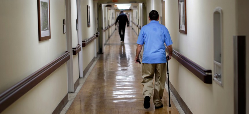 In this March 11, 2015 photo, a patient walks down a hallway at the Fayetteville Veterans Affairs Medical Center in Fayetteville, N.C. The VA hospital is one of the most backed-up facilities in the country.