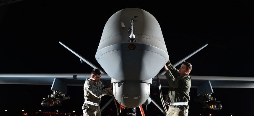 Airman 1st Class Steven (left) and Airman 1st Class Taylor prepare an MQ-9 Reaper for flight during exercise Combat Hammer, May 15, 2014, at Creech Air Force Base, Nev. 