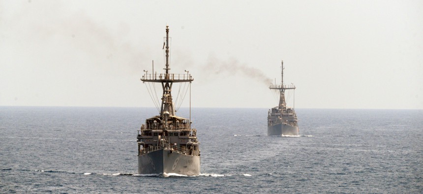 The mine countermeasure ships USS Scout (MCM 8), left, and USS Gladiator (MCM 11), transit the Strait of Hormuz.