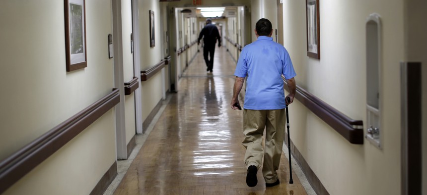 In this March 11, 2015 photo, a patient walks down a hallway at the Fayetteville Veterans Affairs Medical Center in Fayetteville, N.C. 