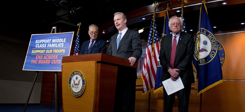 Rep. Chris Van Hollen, D-Md.,, center, flanked by Sen. Bernie Sanders, I-Vt., right, and Sen. Charles Schumer, D-N.Y., speaks during a news conference on Capitol Hill in Washington, Wednesday, April 29, 2015, to speak out against the Republican budget.