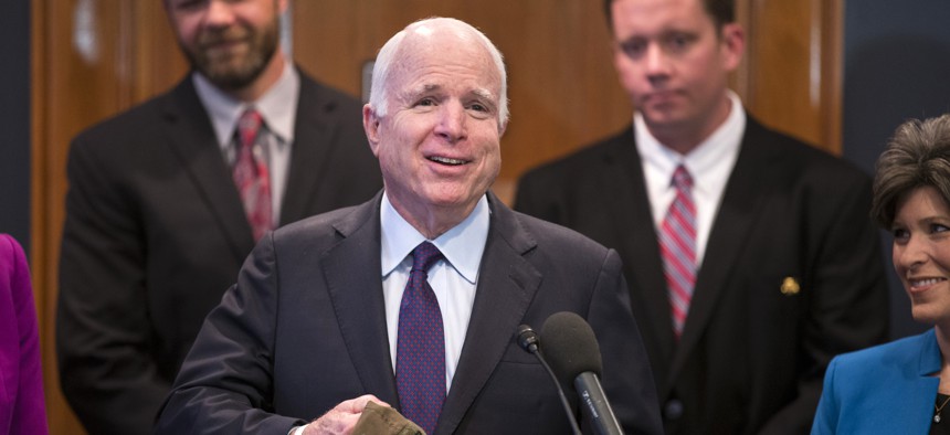 Senate Armed Services Committee Chairman Sen. John McCain, R-Ariz. holds a hat with an image of the A-10 aircraft and the word 'treason' given to him prior to a news conference on Capitol Hill in Washington,Tuesday, May 5, 2015.