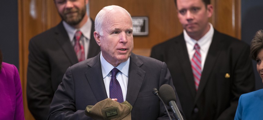 Senate Armed Services Committee Chairman Sen. John McCain, R-Ariz. holds a hat with an image of the A-10 aircraft and the word 'treason' given to him prior to a news conference on Capitol Hill in Washington,Tuesday, May 5, 2015.