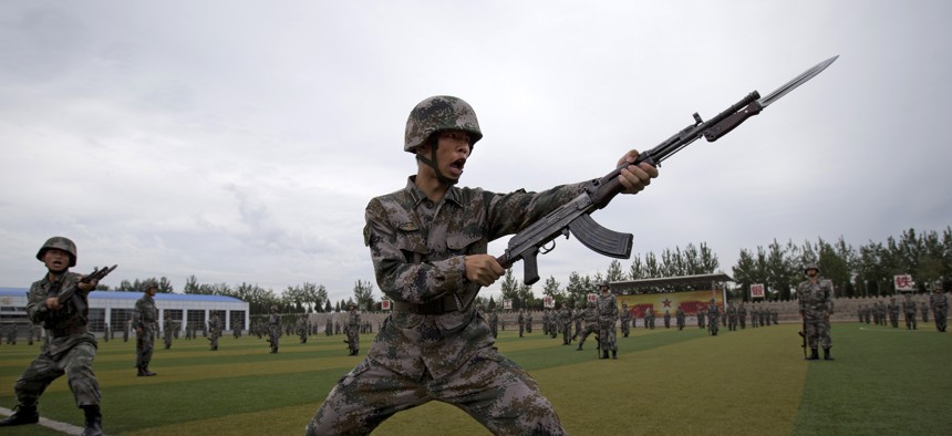 Chinese People's Liberation Army cadets take part in a bayonet drills at the PLA's Armoured Forces Engineering Academy Base, on the outskirt of Beijing, China Tuesday, July 22, 2014. 