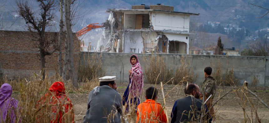 n this Feb. 26, 2012 file picture, a Pakistan family watches the destruction of Osama bin Laden's compound in Abbottabad, Pakistan. 