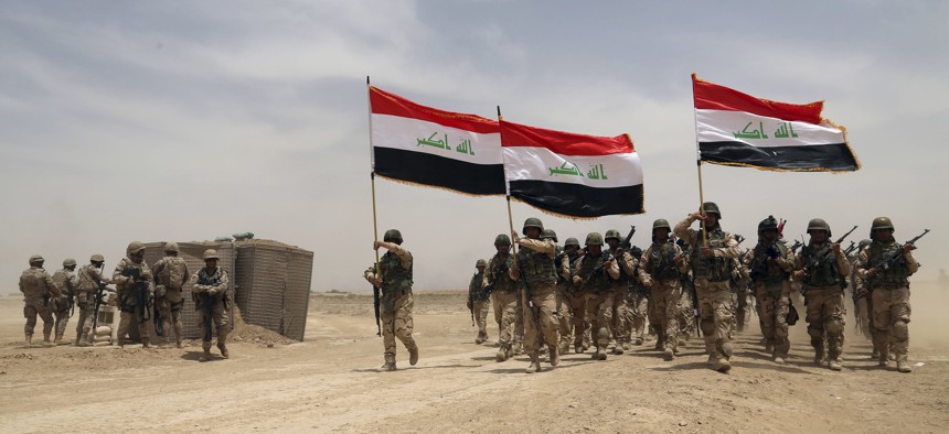 U.S. soldiers, left, participate in a training mission with Iraqi army soldiers outside Baghdad, Iraq, Wednesday, May 27, 2015.