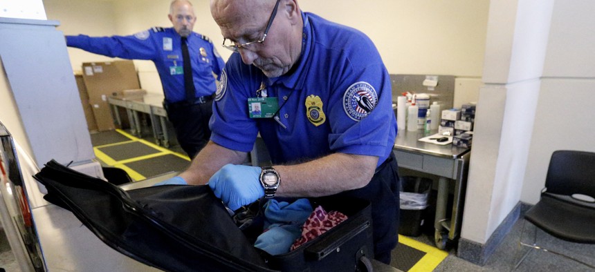 A TSA agent checks a bag at a security checkpoint area at Midway International Airport in Chicago, on November 21, 2014.