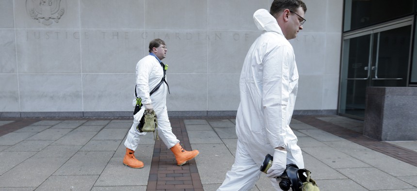 Firefighters in protective clothing prepare to enter the U.S. Courthouse in Philadelphia Wednesday, Feb. 20, 2013. 