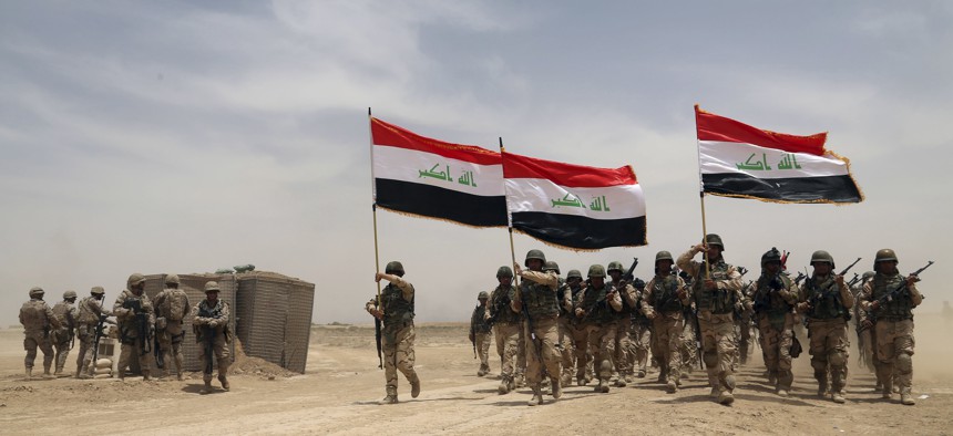U.S. soldiers, left, participate in a training mission with Iraqi army soldiers outside Baghdad, Iraq, Wednesday, May 27, 2015.