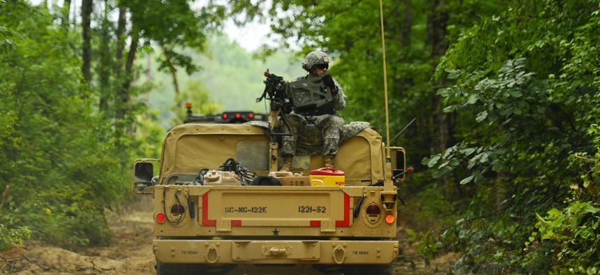 A soldier, assigned to 1221st Route Clearance Company, South Carolina Army National Guard, gunner on top a HMMVV scans for threats during route clearance operations at McCrady Training Center, Eastover, S.C., June 24, 2014. 