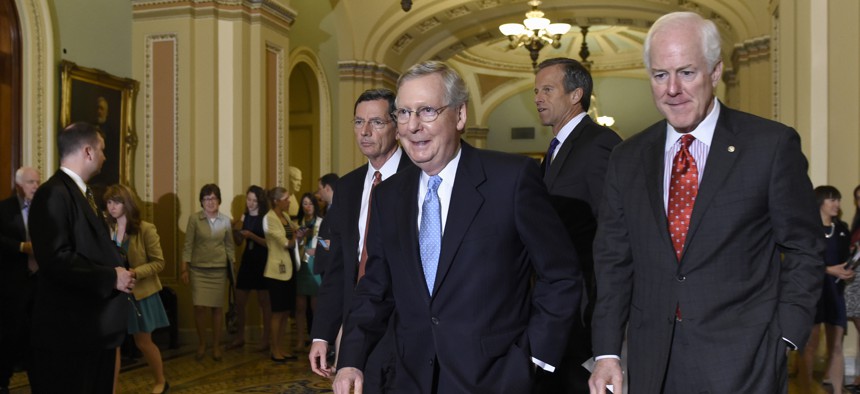 Senate Majority Leader Mitch McConnell of Ky., second from left, walks to the podium to speak to reporters following the weekly Republican luncheon on Capitol Hill in Washington, Tuesday, June 16, 2015. 