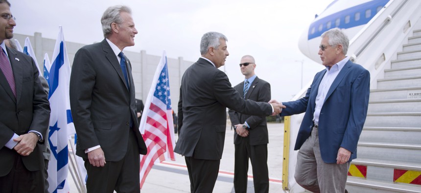 Former Defense Secretary Chuck Hagel shakes hands with Director General of the Israeli Ministry of Defense Udi Shani, as former Israeli Ambasssador to the U.S. Michael Oren looks on. 
