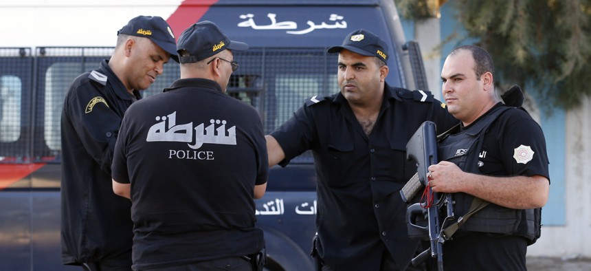 Tunisian police officers guard the street near the attacked Imperial Marhaba hotel in Sousse, Tunisia, Saturday, June 27, 2015.