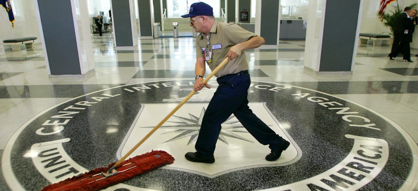 A workman quickly slides a dustmop over the floor at the Central Intelligence Agency headquarters during a visit by President George W. Bush, on March 3, 2005.