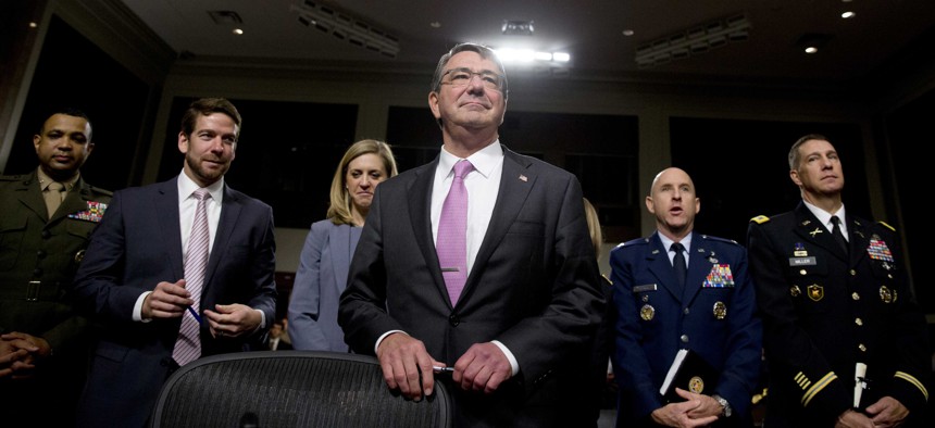 Defense Secretary Ash Carter stands by his seat as he arrives at the Senate Armed Services Committee hearing on Capitol Hill in Washington, Tuesday, July 7, 2015.