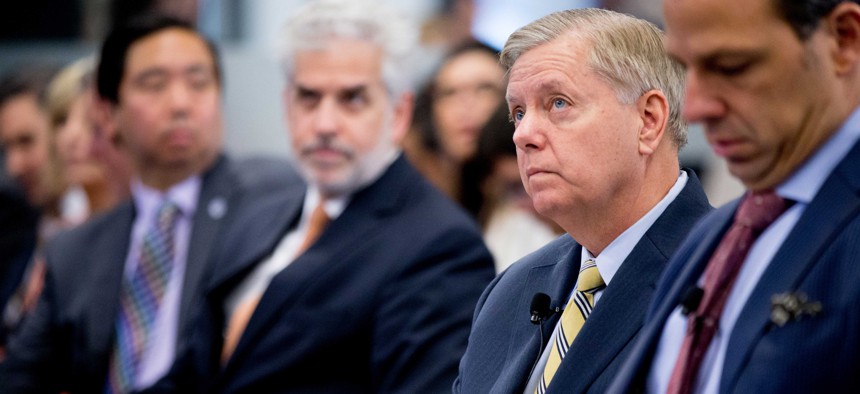 Republican presidential candidate Sen. Lindsey Graham, R-S.C., right, accompanied by CNN journalist Jake Tapper, left, speaks on stage during an Atlantic Council event on July 8, 2015.