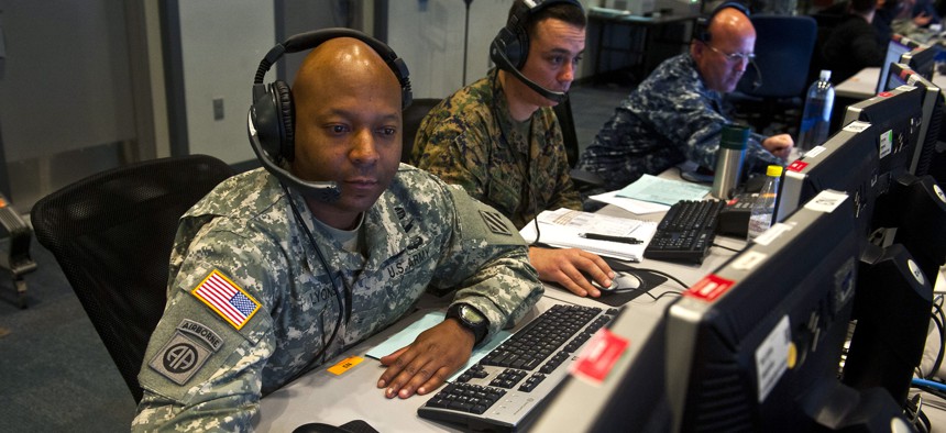 Two cyber operators look at their workstations during Exercise Red Flag, on March 12, 2014.