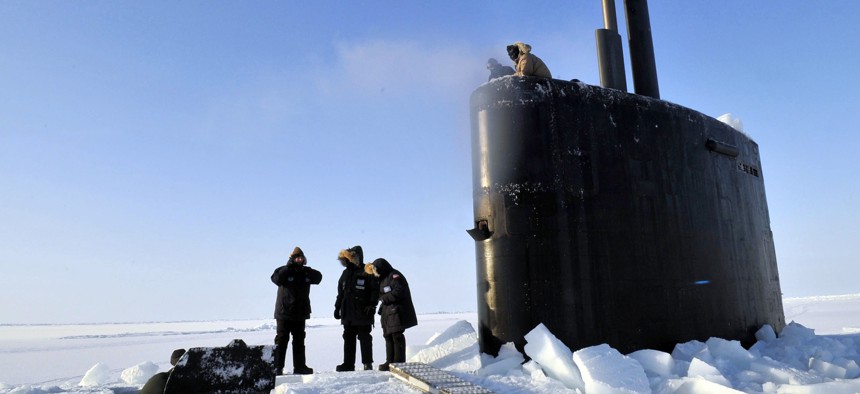 Members of the Applied Physics Laboratory Ice Station clear ice from the hatch of the Los Angeles-class submarine USS Annapolis after the sub broke through the ice while participating in Ice Exercise 2009 in the Arctic Ocean. 