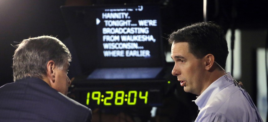 Wisconsin Gov. Scott Walker, right, gives a broadcast interview after announcing that he is running for the 2016 Republican presidential nomination at the Waukesha County Expo Center, Monday, July 13, 2015, in Waukesha, Wis. 
