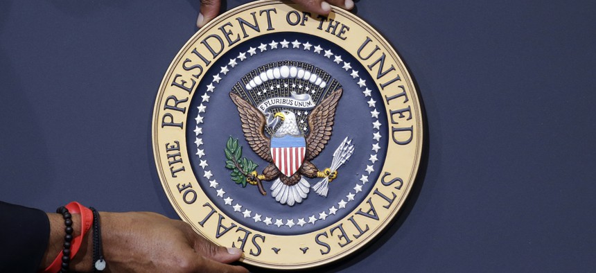 The presidential seal is placed on the podium ahead of President Barack Obama's visit to Lackawanna College Friday, Aug. 23, 2013, in Scranton, Pa. 