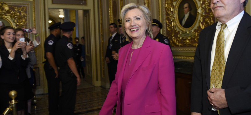 Hillary Clinton walks with David McCallum, deputy chief of staff for Sen. Harry Reid, as they arrive for the weekly policy luncheon with Senate Democrats on Capitol Hill, on July 14, 2015.