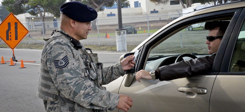 A California Air National Guard NCO checks an idenitification card at the main gate to Moffett Federal Airfield, Calif., on Dec. 8, 2014.