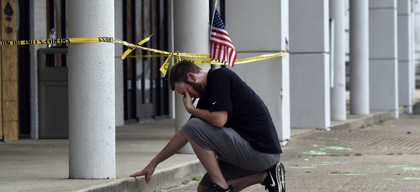 Ryan Scafe prays in front of the Armed Forces Career Center Monday, July 20, 2015, in Chattanooga, Tenn. 