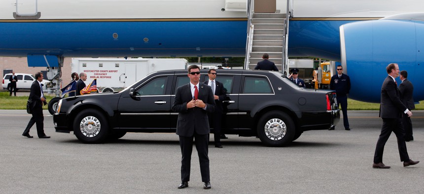Secret service agents protect President Barack Obama as he walks up the steps to Air Force One before departing Westchester County Airport in Harrison, N.Y., Wednesday, May 20, 2015. 