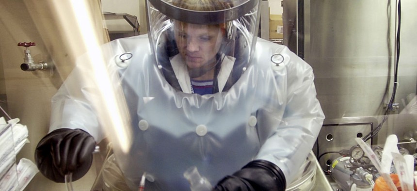 A microbiologist at Life Sciences Test Facility at Dugway Proving Ground, Utah, works in a specialized airtight enclosure designed for use with deadly agents. 