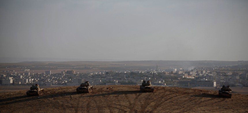 Turkish soldiers hold their positions with their tanks on a hilltop in the outskirts of Suruc, at the Turkey-Syria border, Oct. 10, 2014.