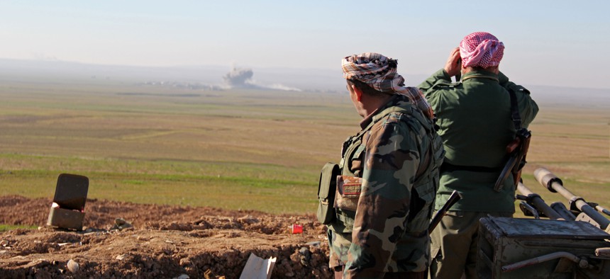 In this Tuesday, Jan. 20, 2015 image released by the Kurdistan Region Security Council (KRSC), Kurdish peshmerga forces watch smoke rise as fighters target Islamic State group positions in northern Iraq.